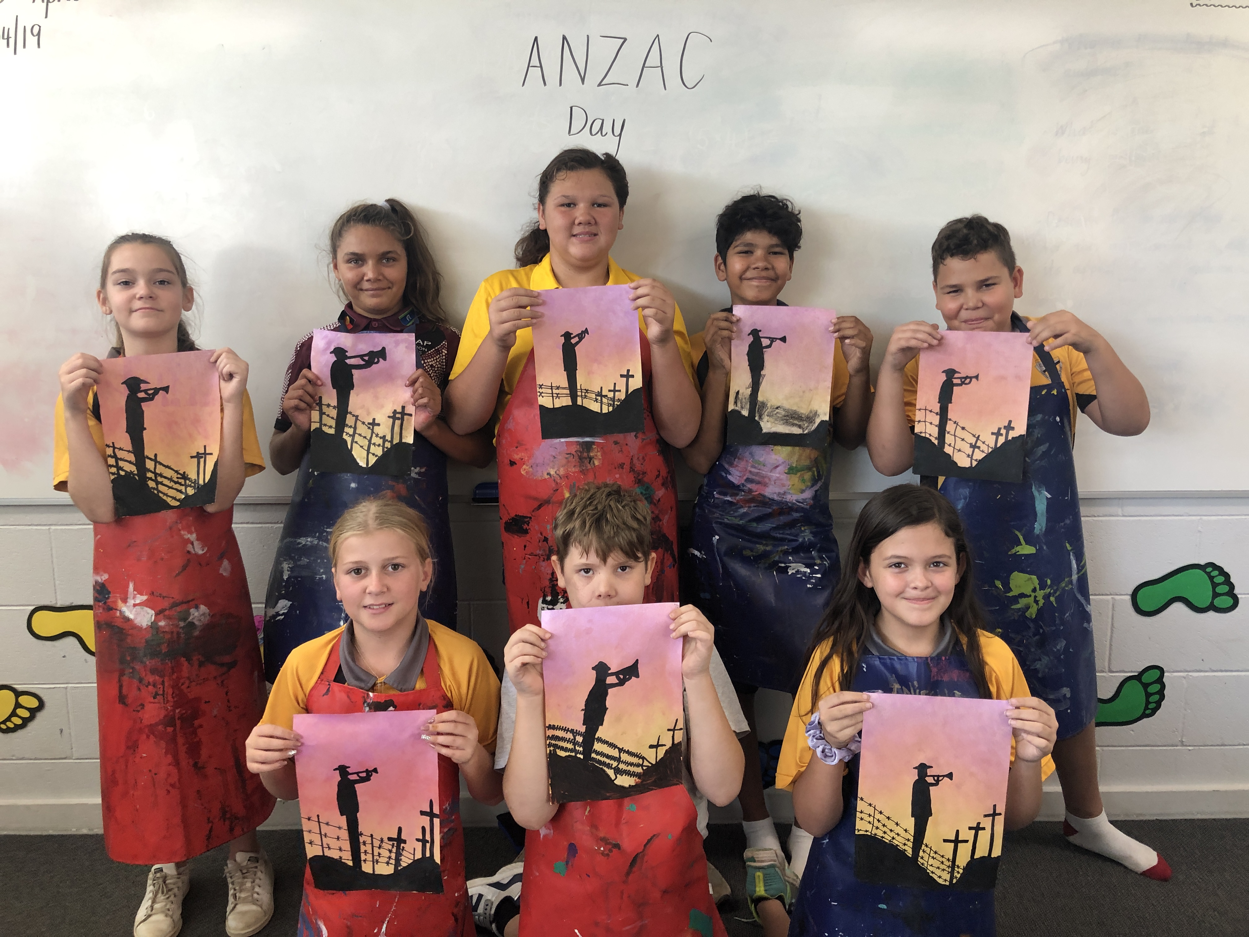 Students holding up artwork they created for ANZAC Day
